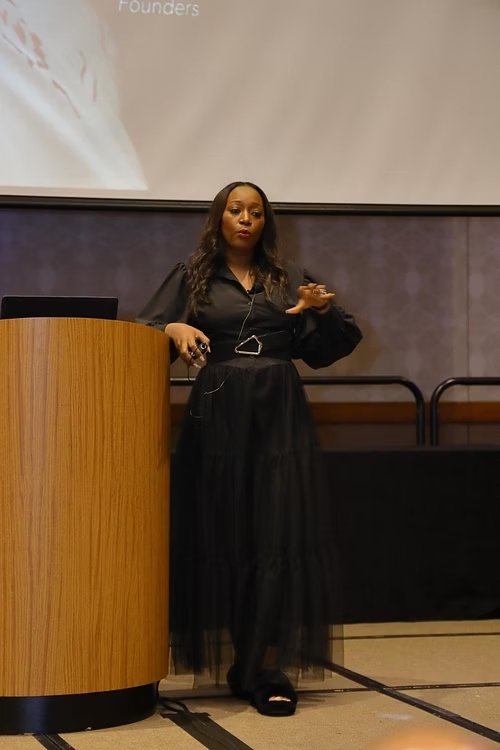 Krystal Johnson speaking from the stage at a corporate event